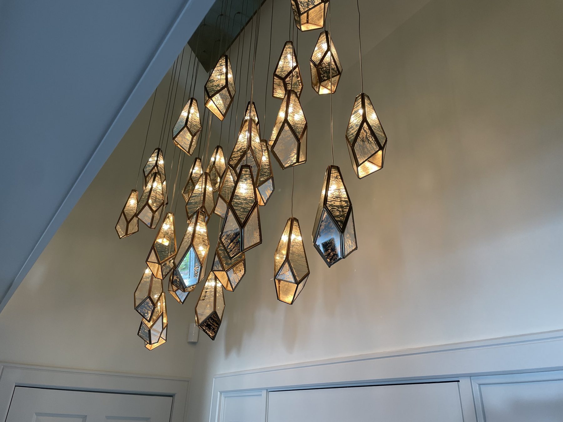 Detail view of geometric crystal pendant fixture with warm interior light
